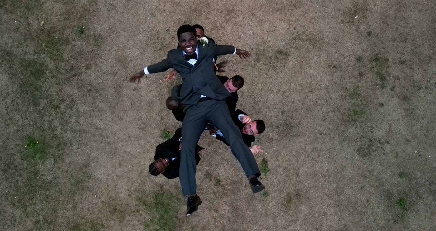 Drone shot of a groom and groomsmen from above - aerial wedding videography by Steer Media