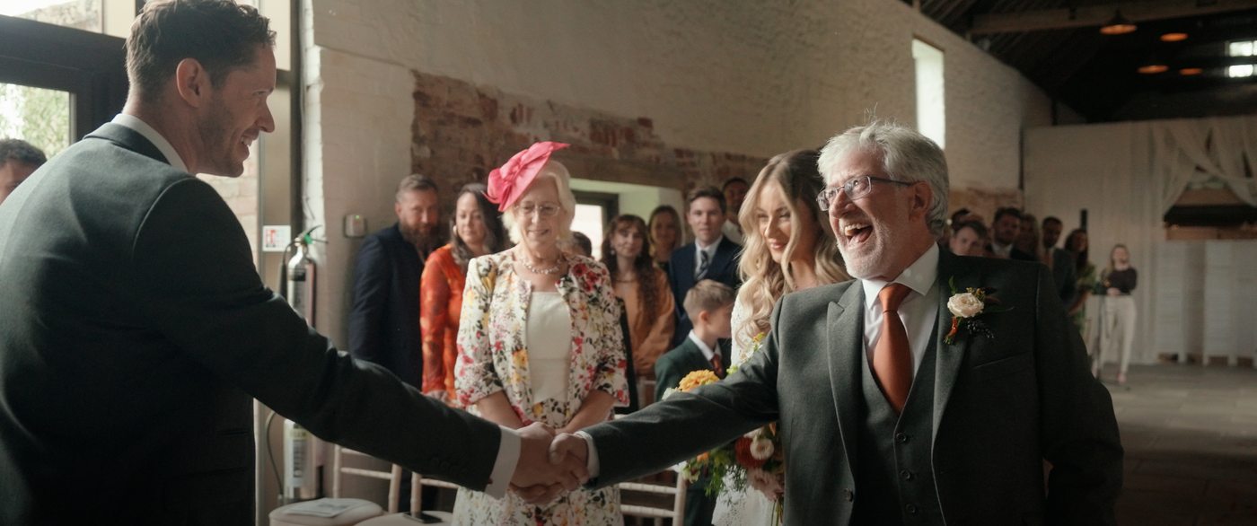 Groom greeting guests at the ceremony - natural wedding film by Steer Media