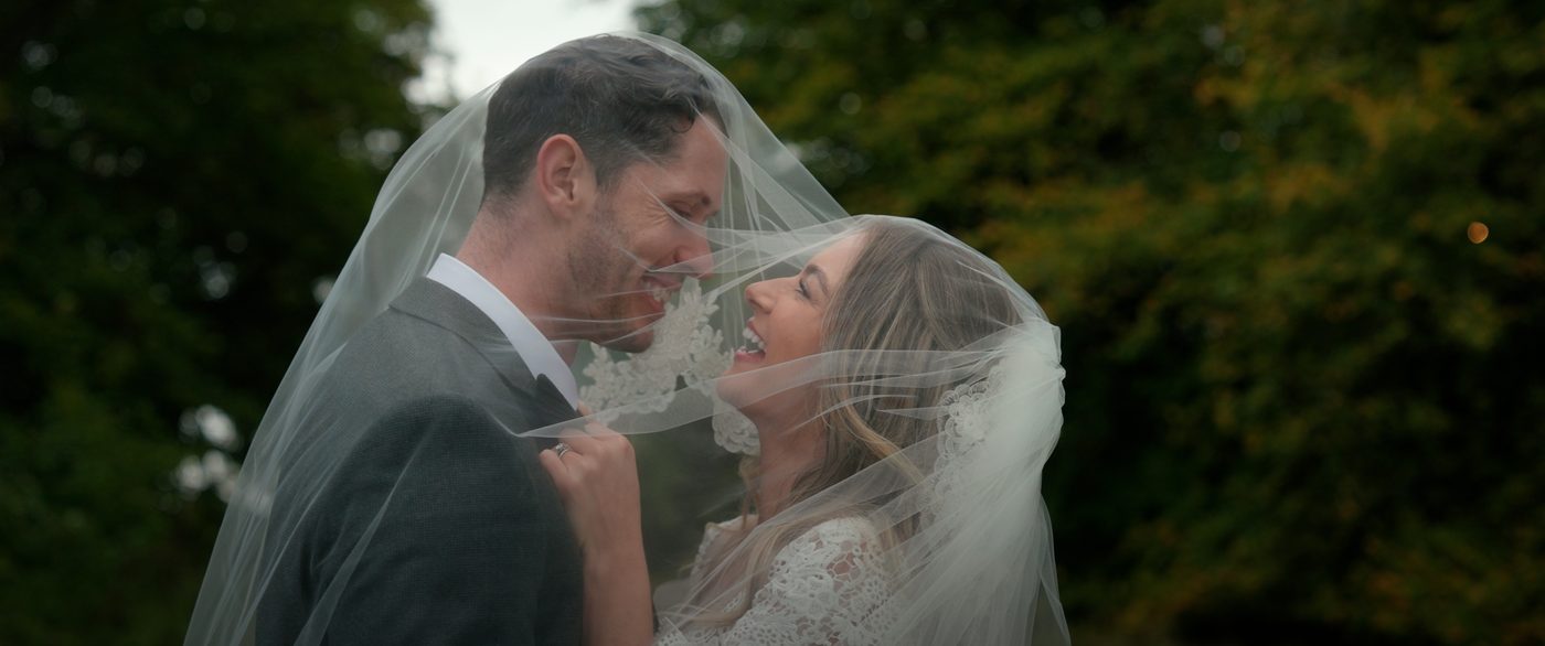 Couple sharing a private moment under the veil - first look wedding videography